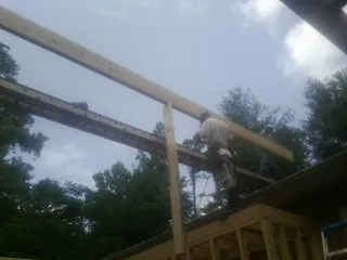 Carpenter setting a ridge beam over a new addition frame — Ice Dam Removal by Roofing Brothers in Howard Lake