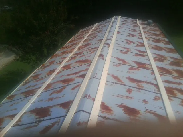 Rusted metal roof panels with new wood purlins before replacement — Storm Damage Roof Repair in Howard Lake by Roofing Brothers