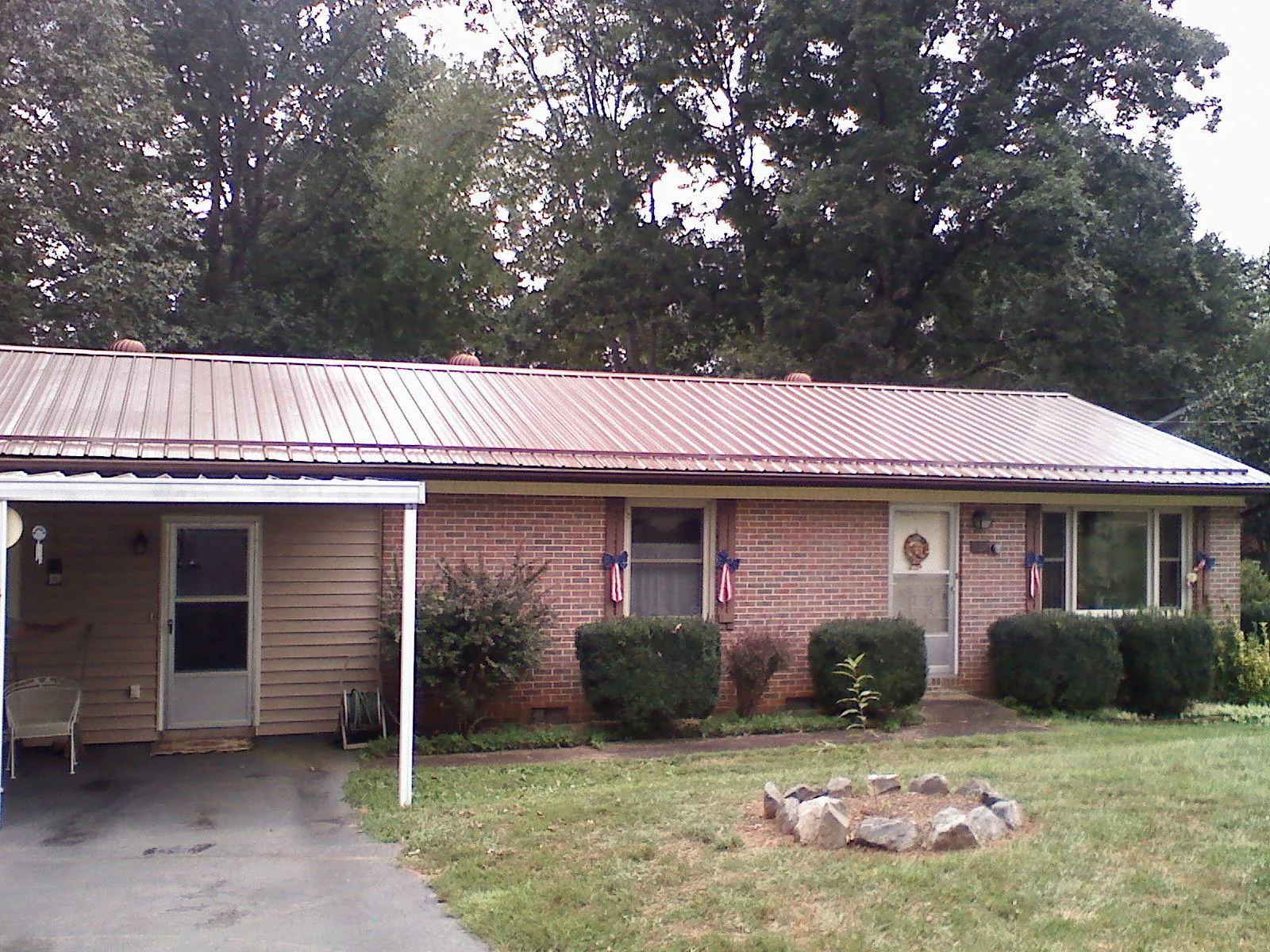 Bronze metal roof and carport on a brick ranch home — Roof Repair work by our crew in Howard Lake